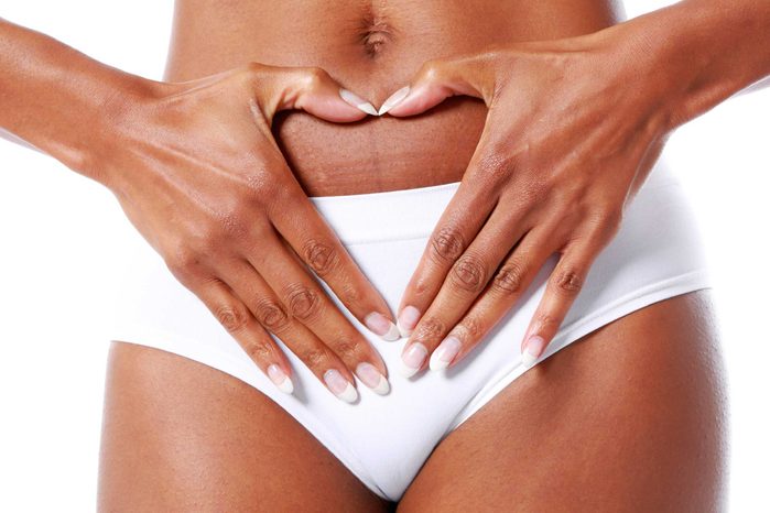 African American woman with her hands by her crotch