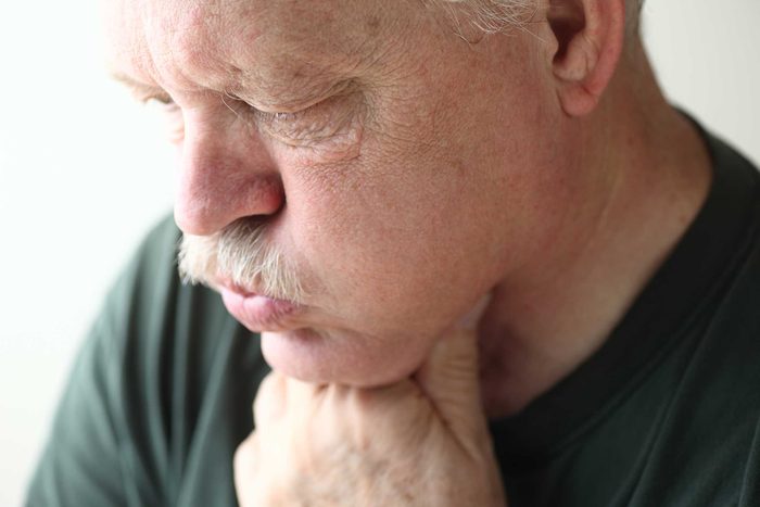 Man grabbing at his neck.