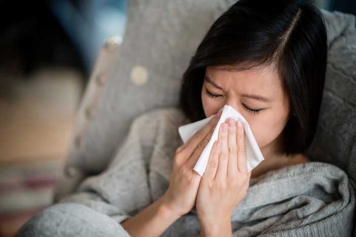 Ill woman blowing her nose.