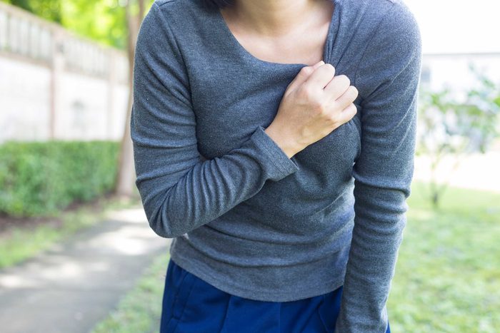 Woman clutching her chest.