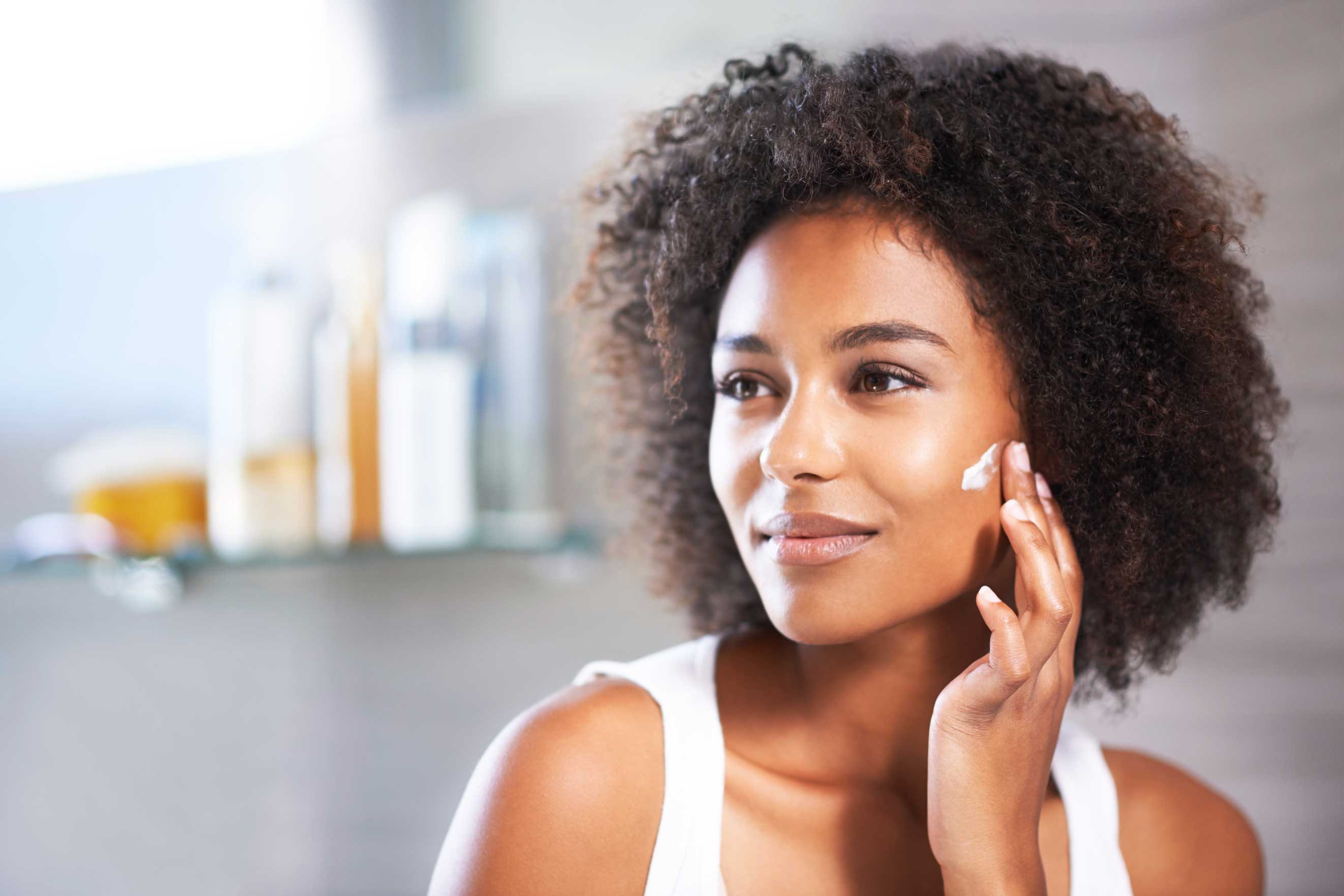 woman applying lotion to her cheek