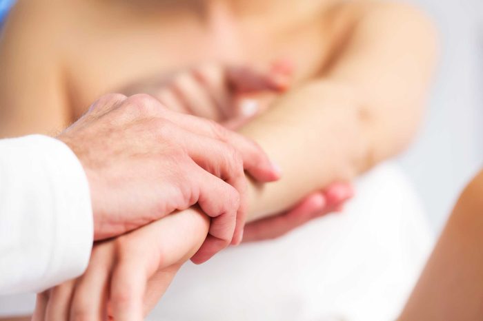 Doctor examining a patient's arm and skin.