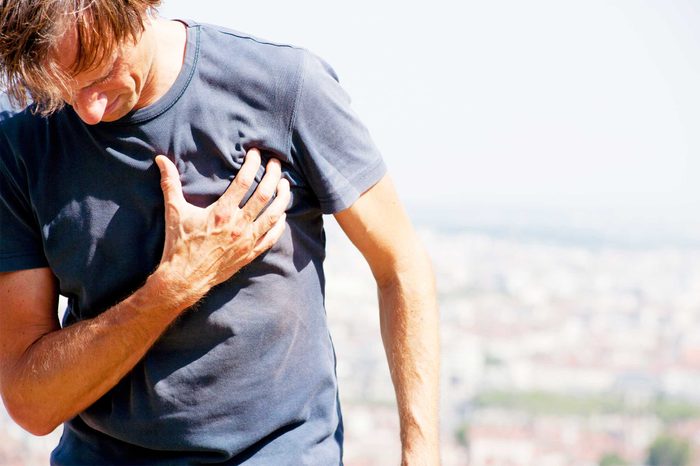 Man outside clutching his chest.