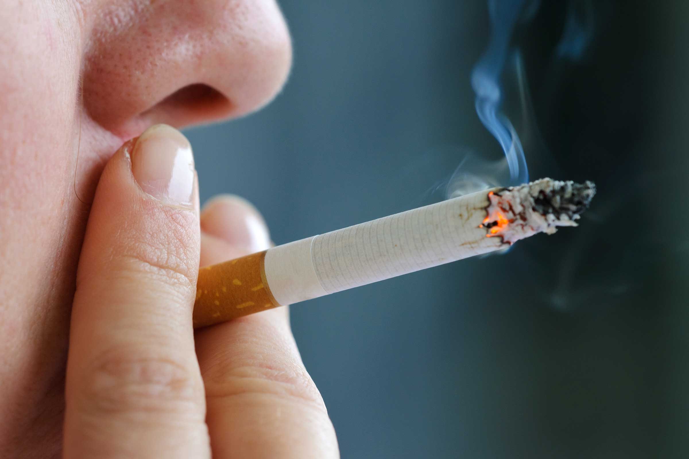close up of person smoking a cigarette