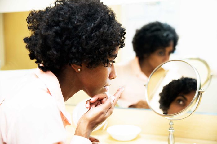 woman applying contact lens to eye
