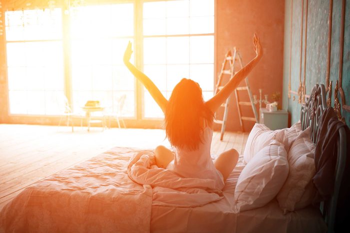 woman stretching in bed