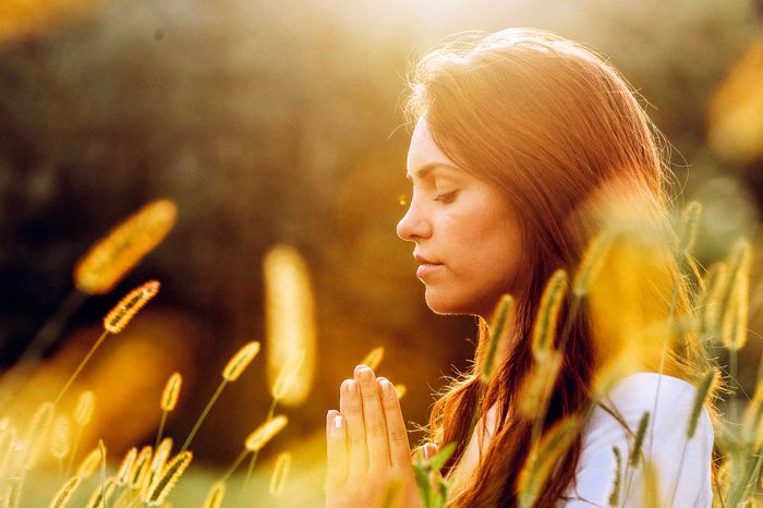 Woman meditating in a field.