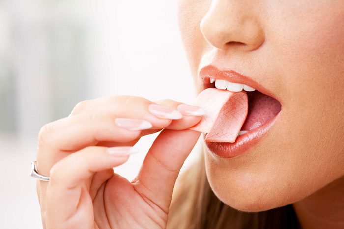woman putting a stick of gum in her mouth