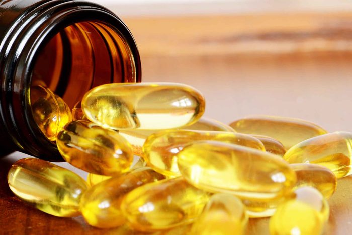 clear vitamin capsule spilling out of a bottle