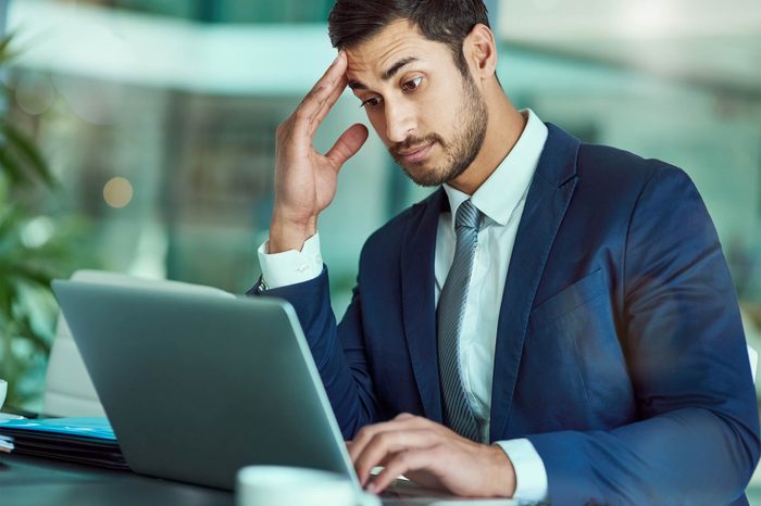 Man looking at laptop screen, seems confused