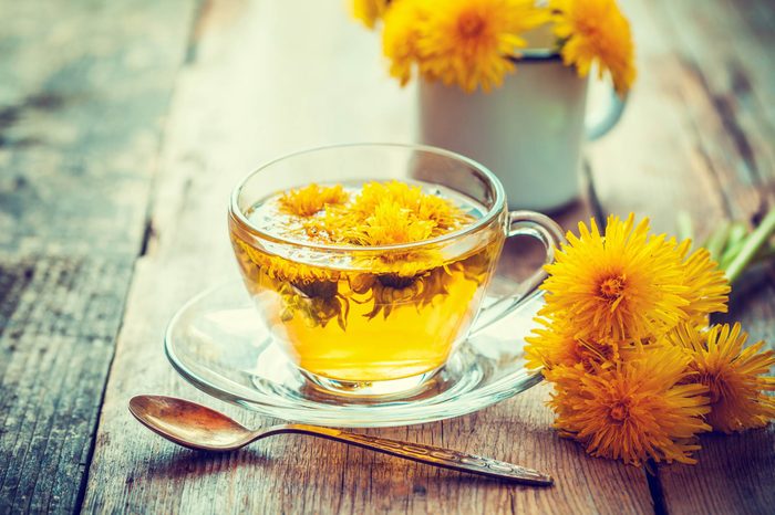 glass mug of elecampane flower tear, next to flowers