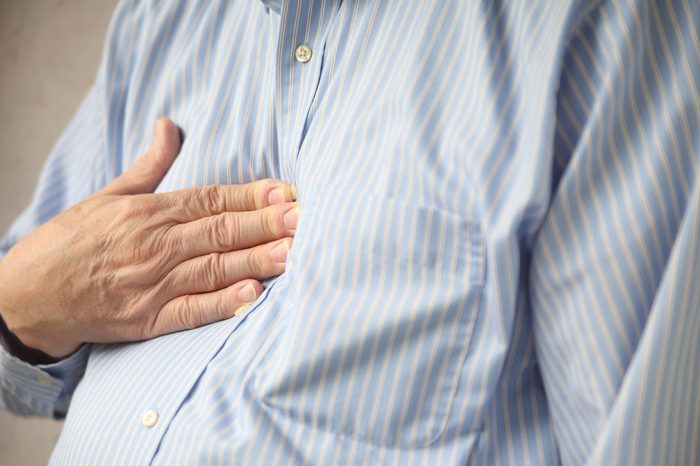 man pressing his hand into his chest
