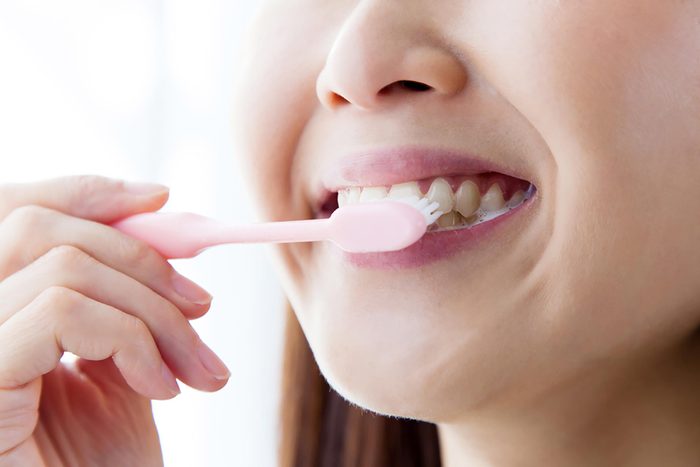 happy woman brushing teeth