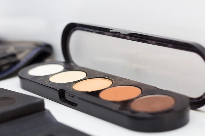 A palate of concealer in shades of brown and tan.