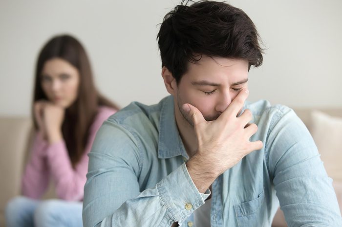 upset woman looking at man with hand over face