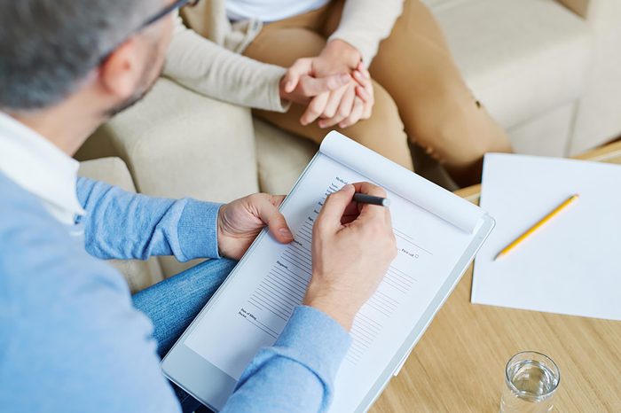therapist taking notes on a pad with patient