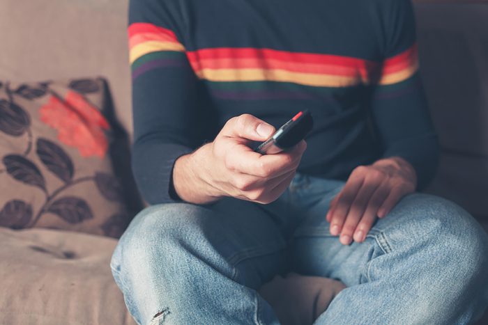 person with tv remote in hand