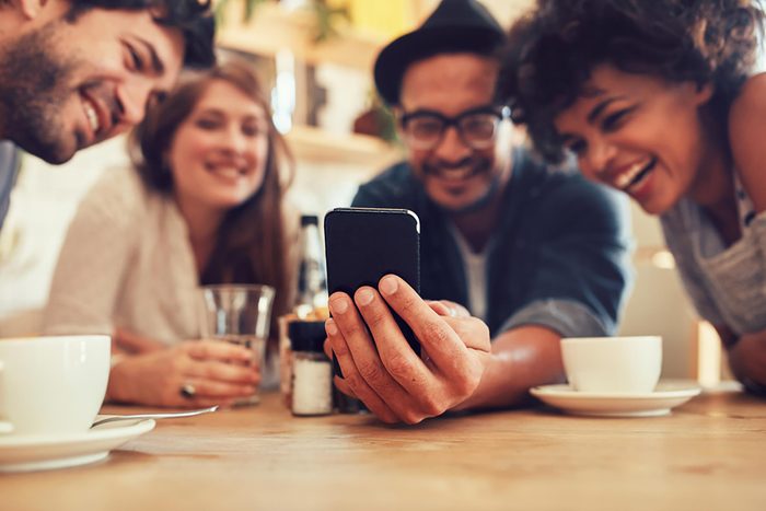 friends looking at phone together