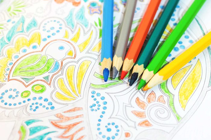 Colored pencils and an adult coloring book.