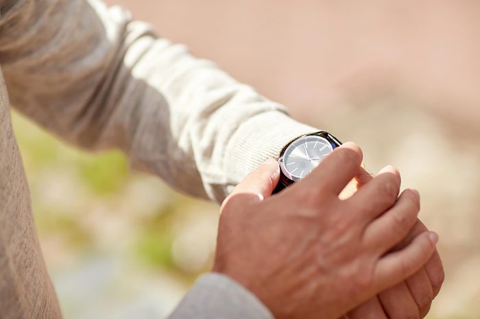 man in the sun checking his watch