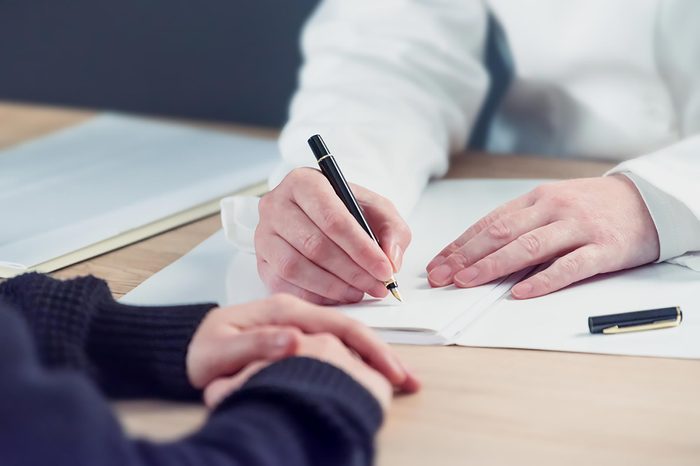 close up of doctor's and patient's hands on a desk