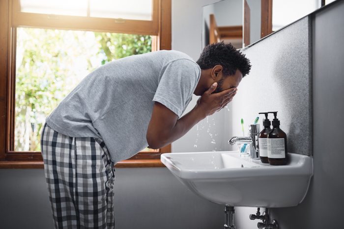 man washing face