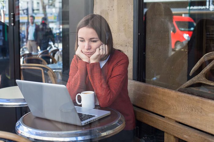 woman at computer looking sad