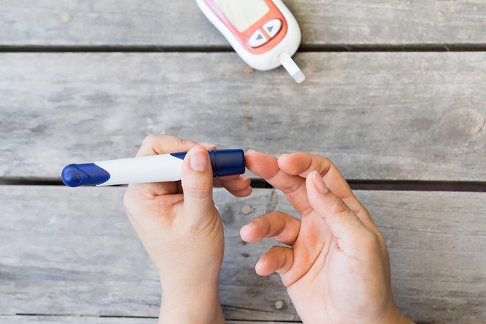someone testing their blood-sugar with finger-stick device
