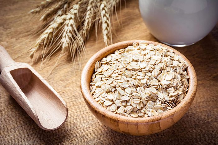 Bowl of raw oats and a wooden scoop