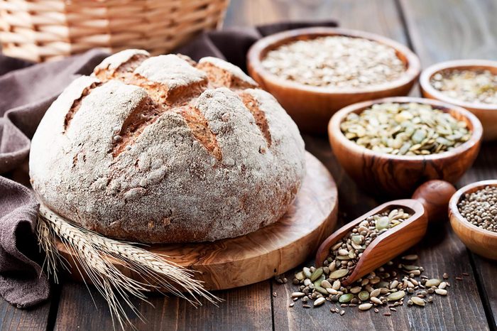 Round loaf of fresh bread plus bowls of legumes
