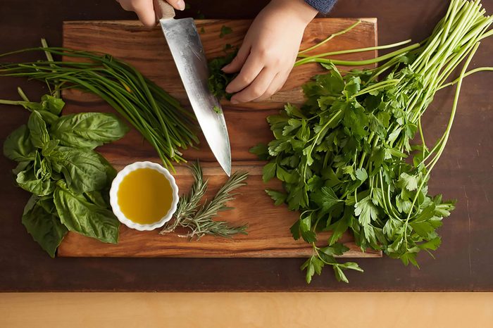 closeup of hand, knife, parsley, olive oil