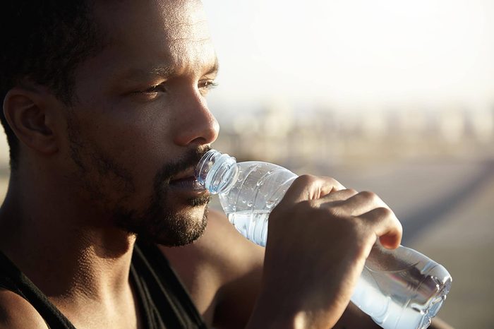 man drinking from a water bottle