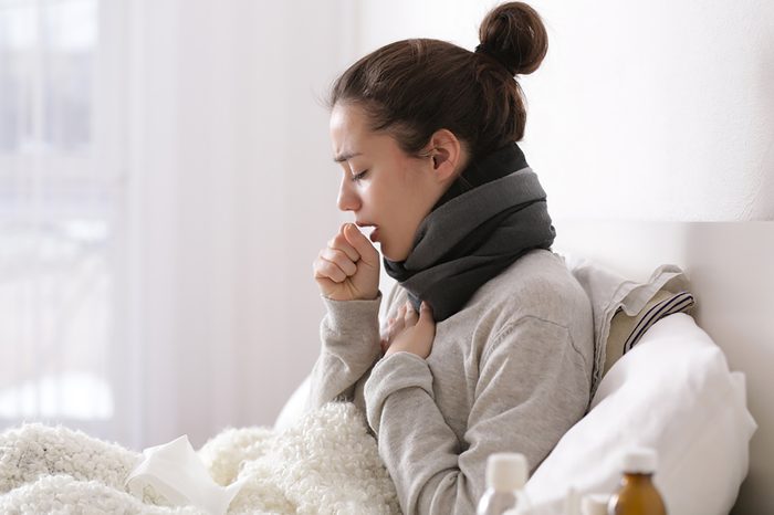 woman coughing in bed