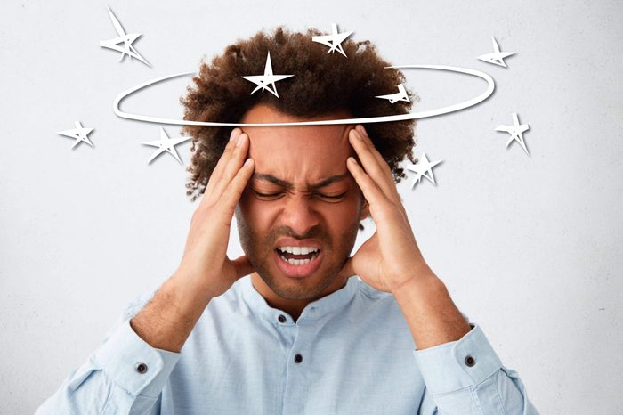 black man in pain and holding his head