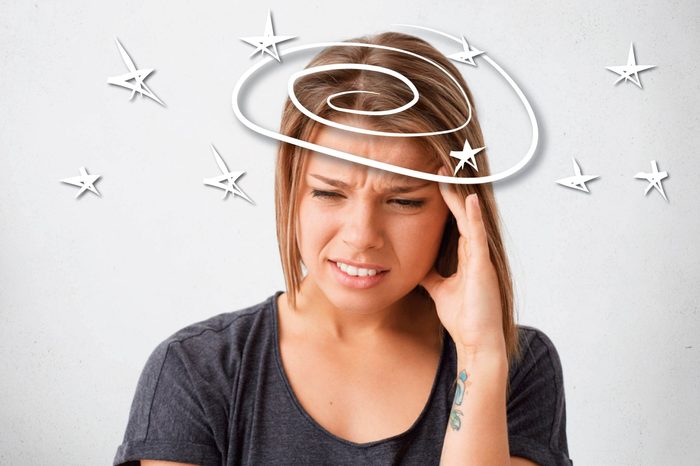 young woman holding the side of her head