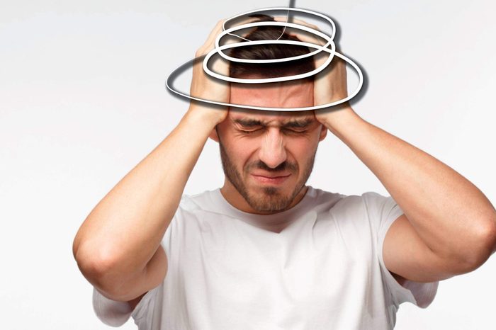 man pressing against his head