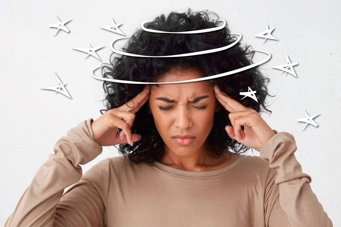 black woman pressing her fingers against her temples