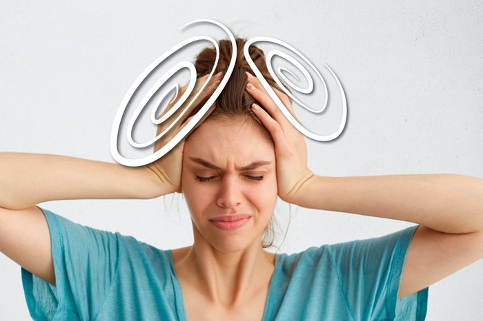 woman squeezing her head with her hands