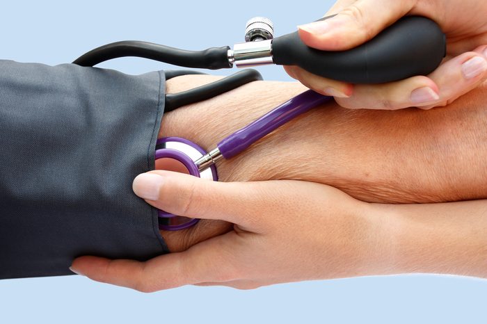Doctor measuring a person's blood pressure with a cuff.