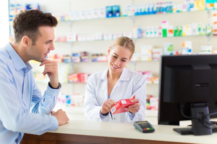 patient talking to pharmacist looking at Rx bottle