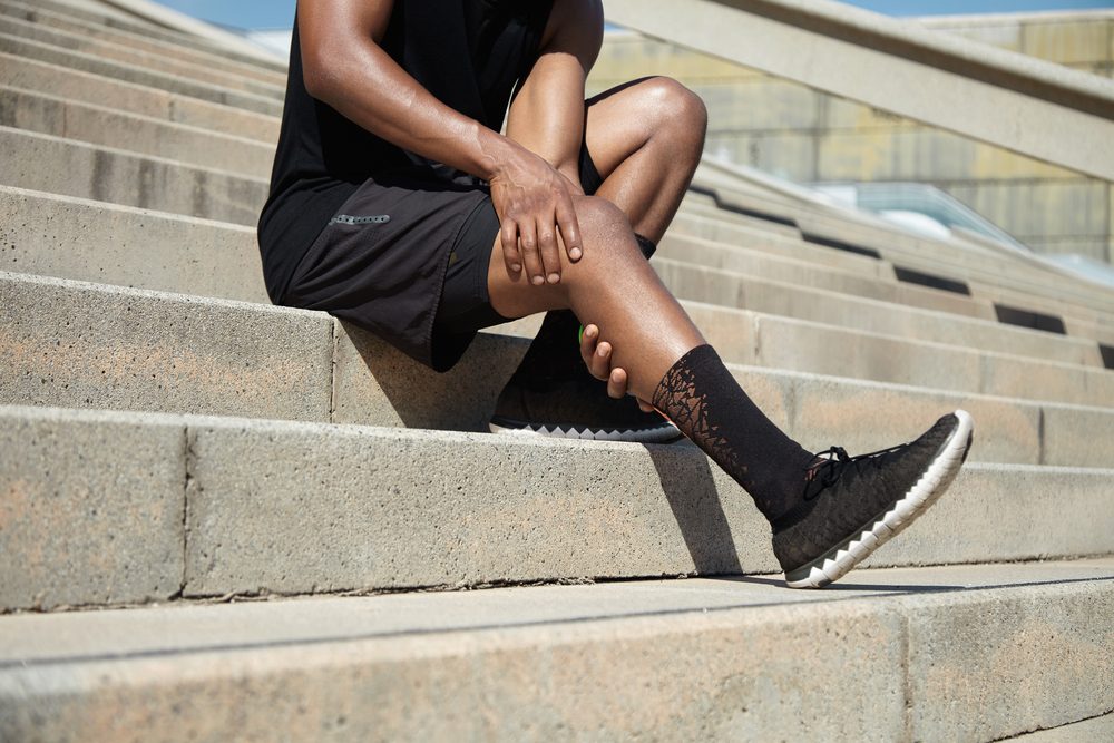 man holding leg in pain on steps