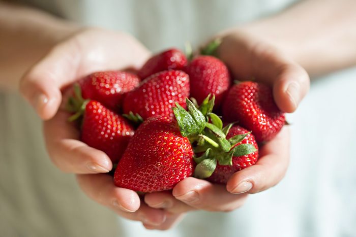 hands holding fresh strawberries