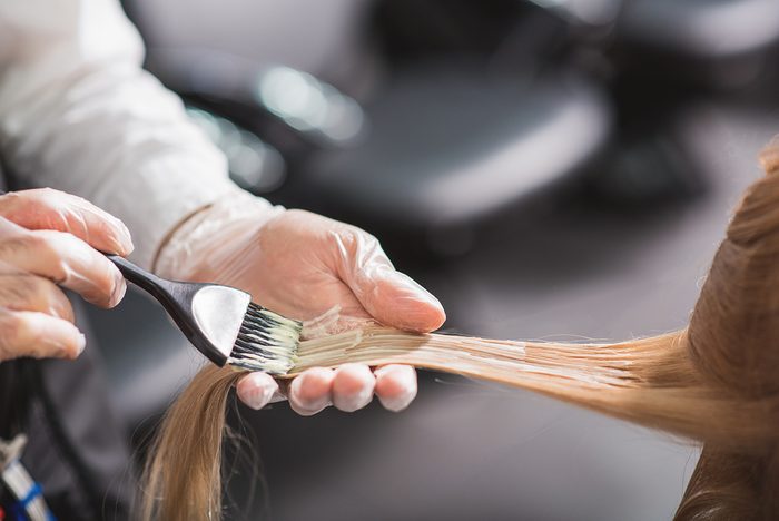 Man in gloves is dying hair