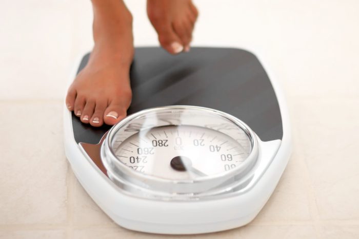 woman stepping on scale