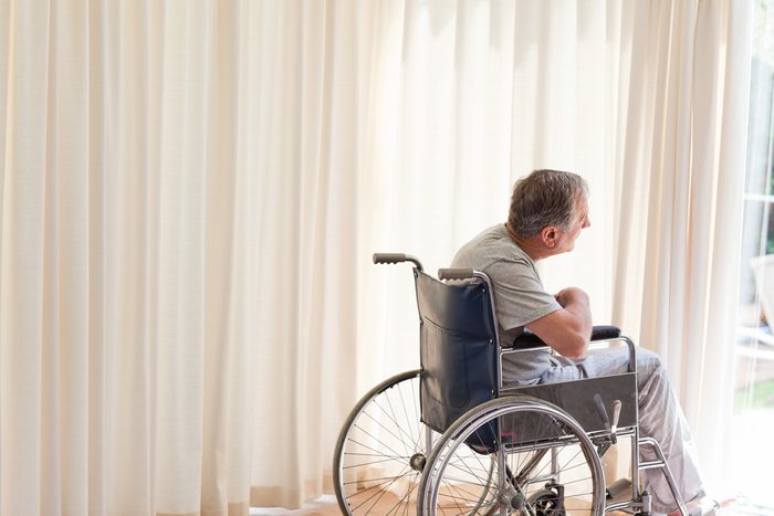 Man in his wheelchair looking out the window