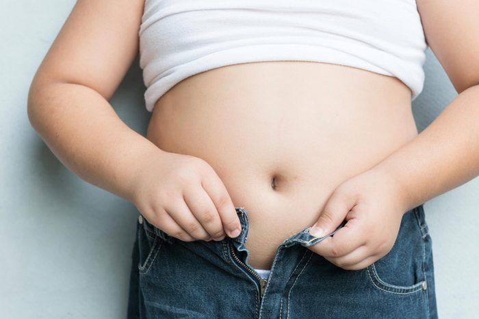 overweight child buttoning jeans