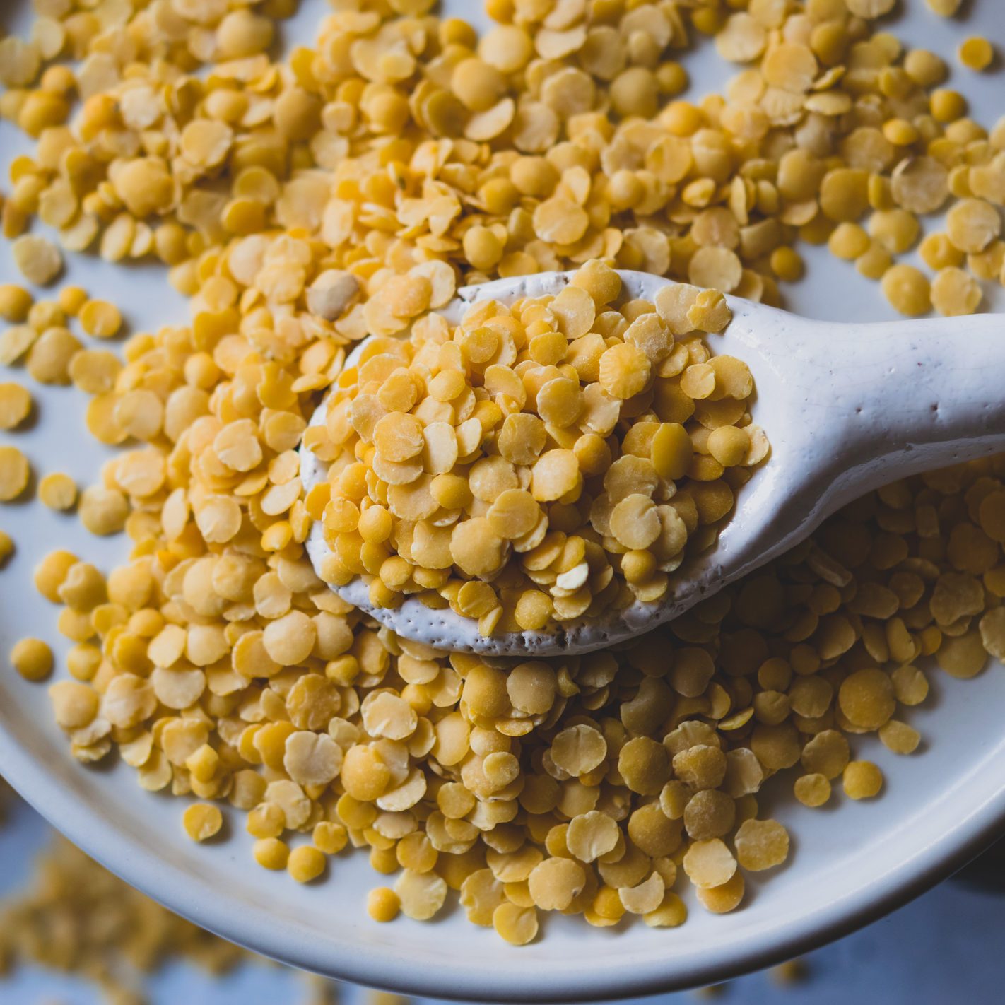 dry yellow lentils on white plate overhead