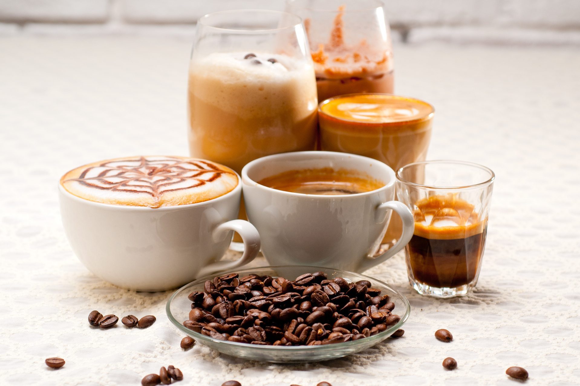 Close-Up Of Coffees With Roasted Coffee Beans Served On Table