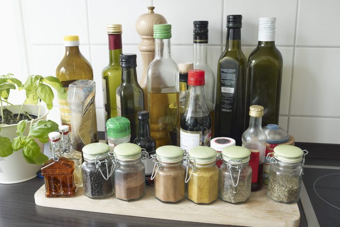 Glasses with herbs and spices in kitchen