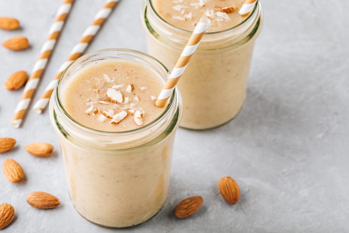 Banana almond smoothie with cinnamon and oat flakes and coconut milk in glass jars
